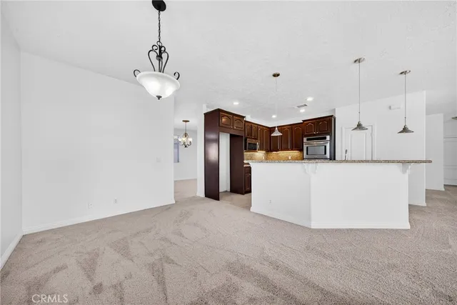 a view of a kitchen with an empty space and wooden floor