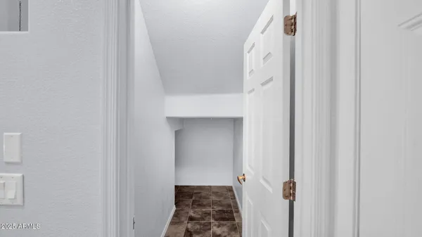 a view of a hallway with white walls and stairs