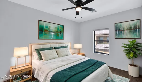 an empty room with wooden floor chandelier fan and windows