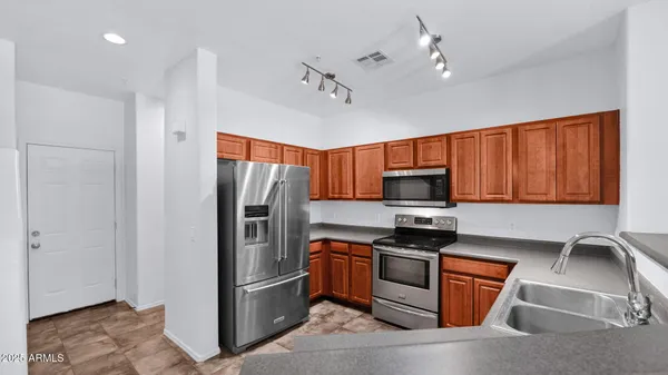 a kitchen with stainless steel appliances granite countertop a refrigerator stove and microwave