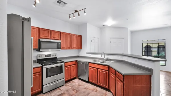 a kitchen with stainless steel appliances granite countertop a sink stove and refrigerator