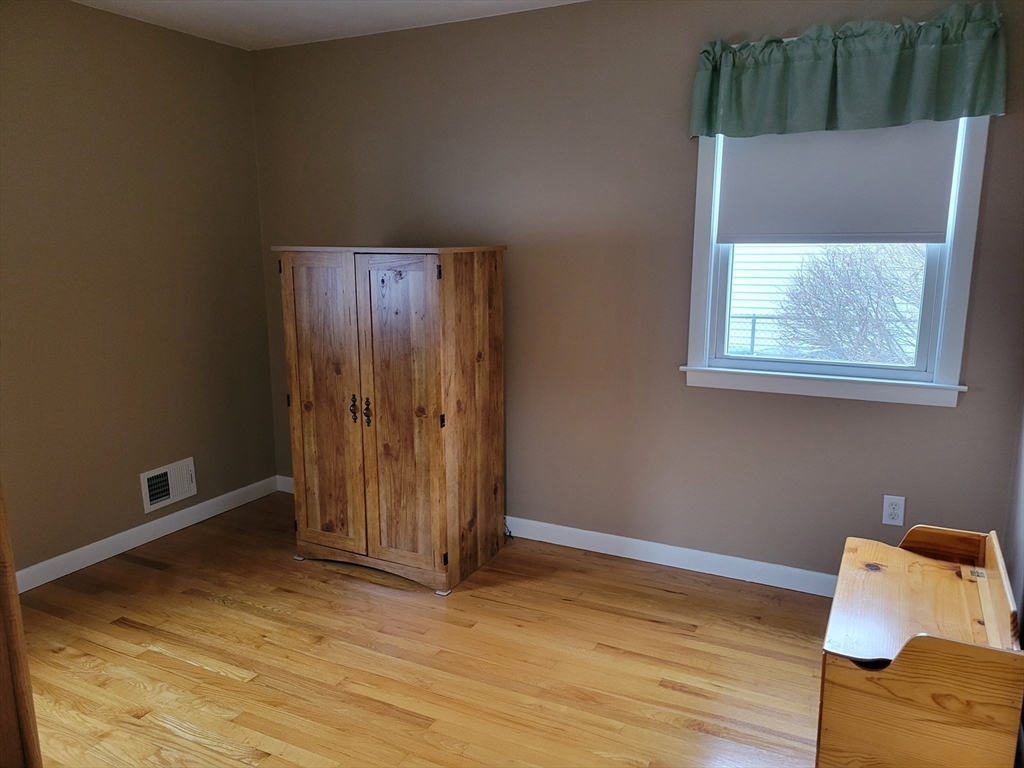 39 Daley Street Chicopee, MA 01013 - Photo 14 of 17 a view of an empty room with wooden floor and a window