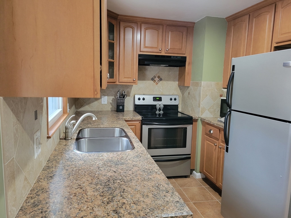 39 Daley Street Chicopee, MA 01013 - Photo 4 of 17 a kitchen with granite countertop a sink stove and refrigerator