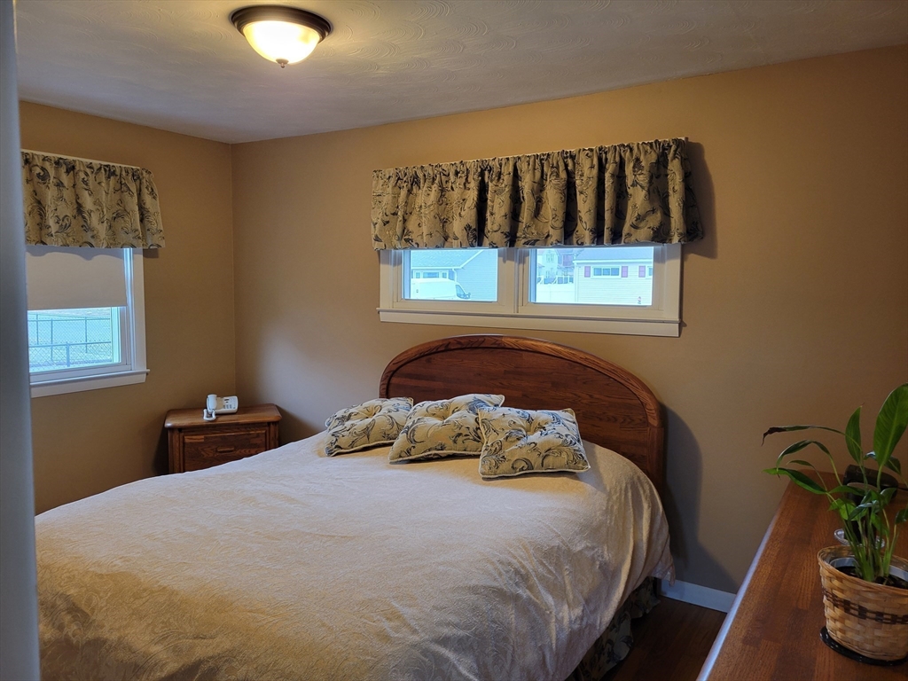 39 Daley Street Chicopee, MA 01013 - Photo 10 of 17 a bedroom with a bed a painting on the wall and a potted plant