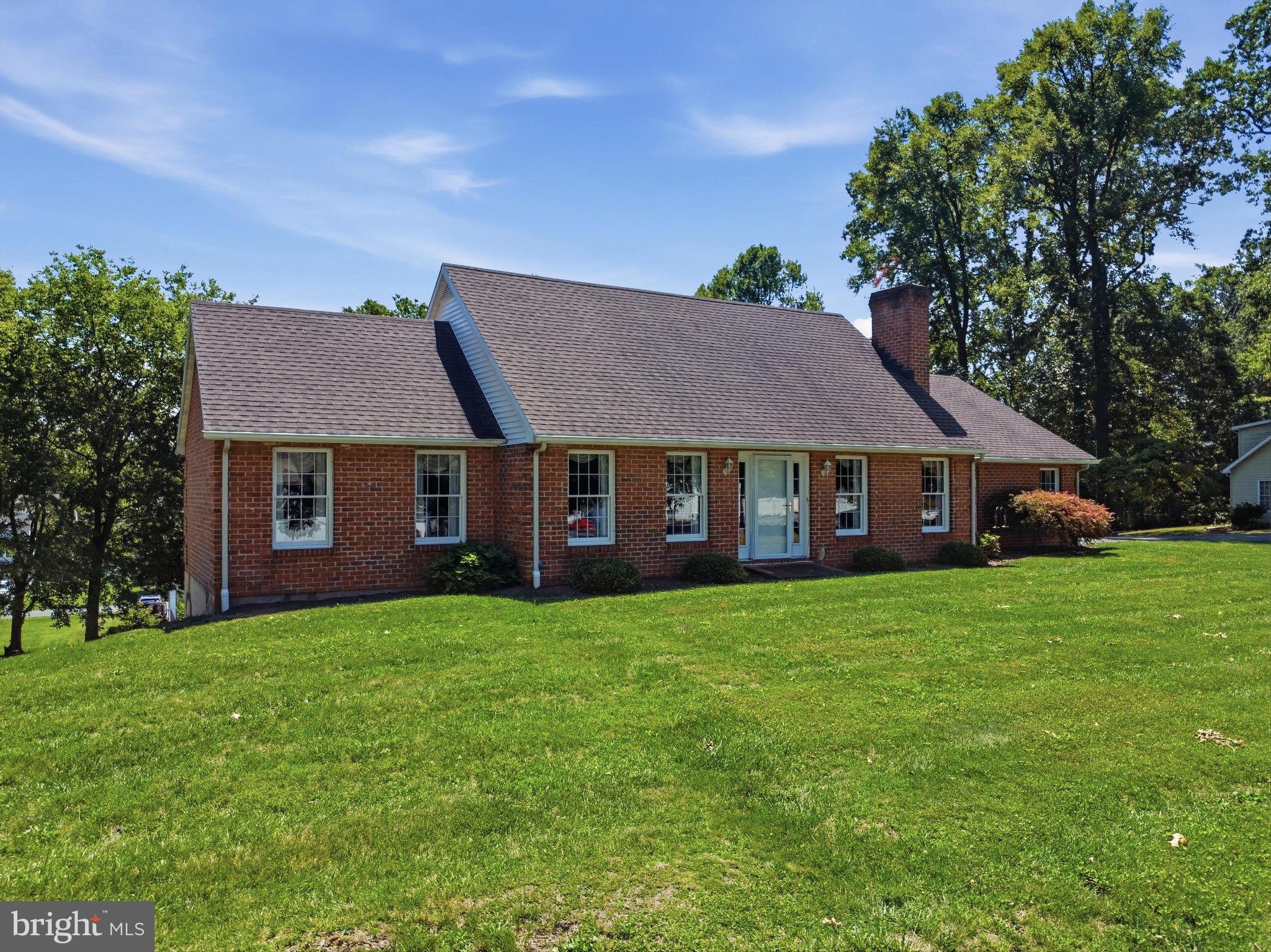 Charming brick home on lush green grounds.