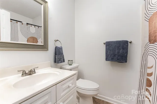 a bathroom with a sink vanity mirror and toilet