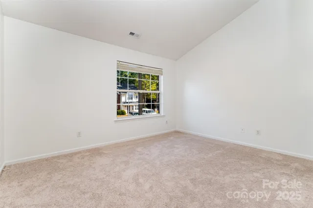 a view of a house with a yard and table and chairs under an umbrella
