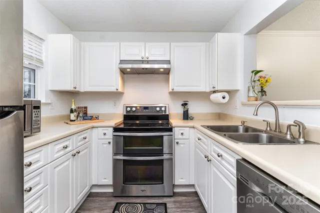 a kitchen with cabinets appliances a sink and a counter top space