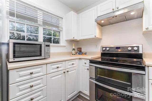 a kitchen with granite countertop a stove and a microwave