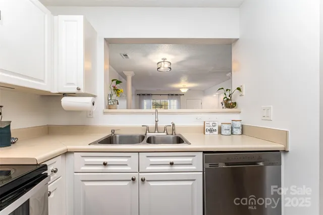 a kitchen with a sink dishwasher and cabinets with wooden floor