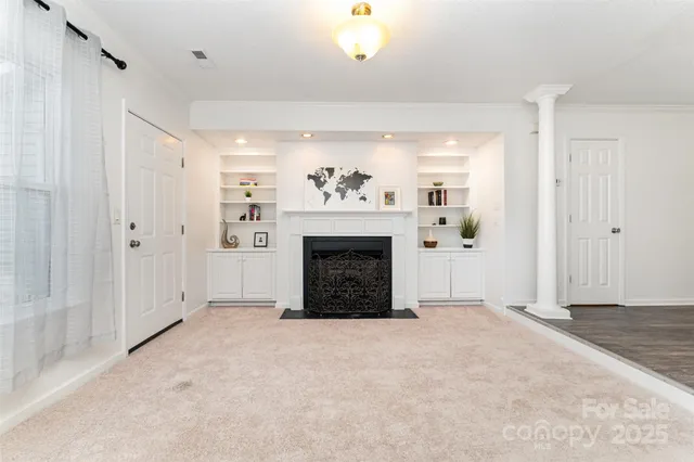 a view of a livingroom with a fireplace cabinet and windows