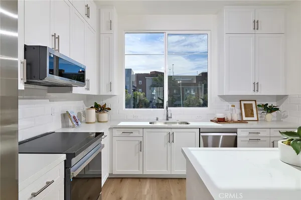 a kitchen with a sink a stove and cabinets