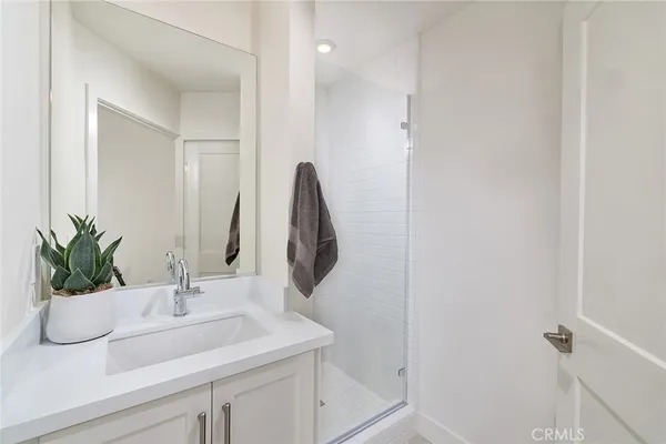 a bathroom with a sink a mirror and a potted plant