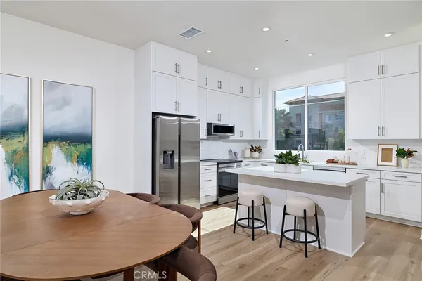 a kitchen with refrigerator cabinets dining table and chairs