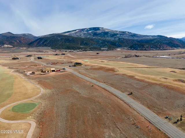 a view of a field with mountains in the background