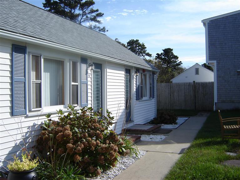 172 Captain Chase Road, Unit 3 Dennis Port, MA 02639 - Photo 1 of 10 a front view of a house with a yard and a garden