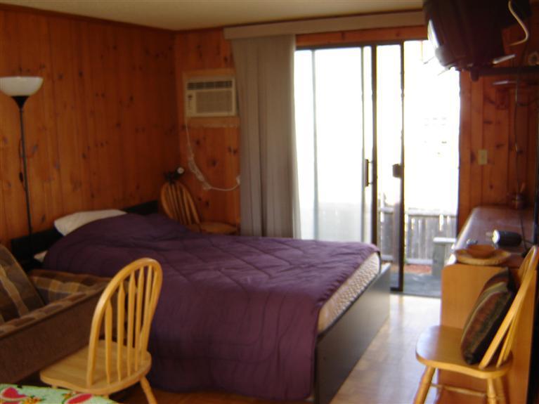 172 Captain Chase Road, Unit 3 Dennis Port, MA 02639 - Photo 4 of 10 a bed sitting in a bedroom next to a window