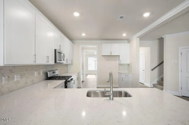a kitchen with stainless steel appliances sinks a refrigerator and cabinets
