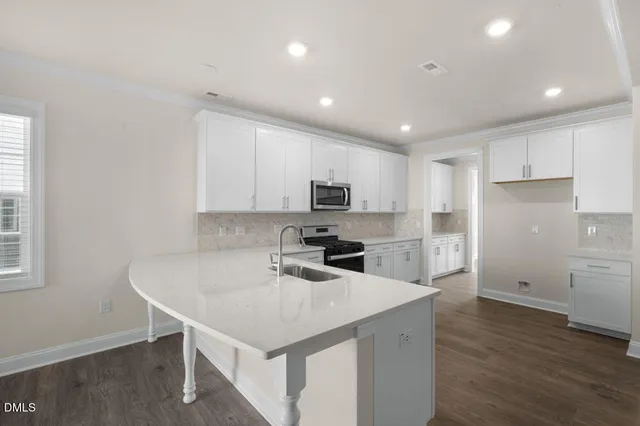 a kitchen with a sink a microwave a refrigerator and cabinets