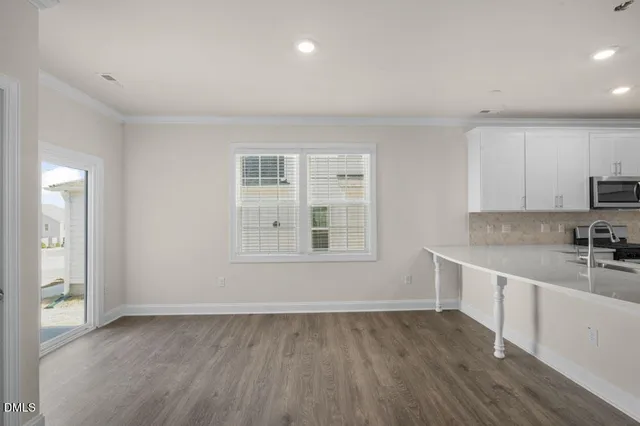 a view of a kitchen with wooden floor and electronic appliances