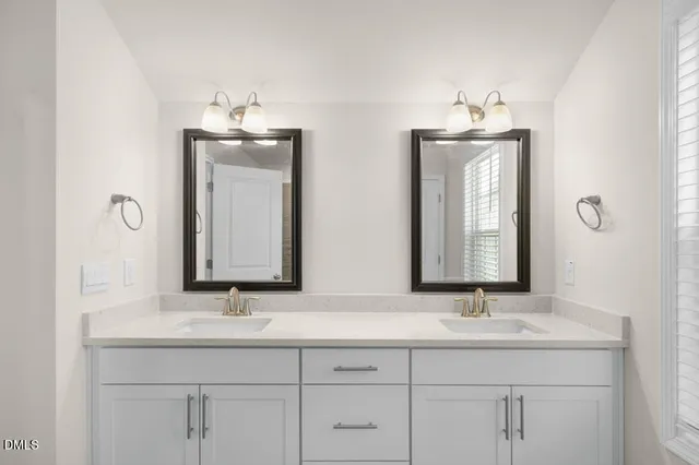 a bathroom with double vanity sinks and a mirror
