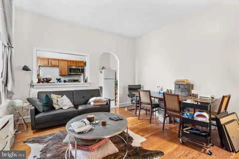 a living room with furniture and a dining table with kitchen view