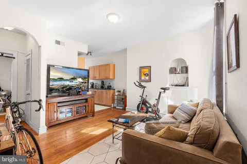 a living room with stainless steel appliances kitchen island granite countertop furniture and a view of kitchen