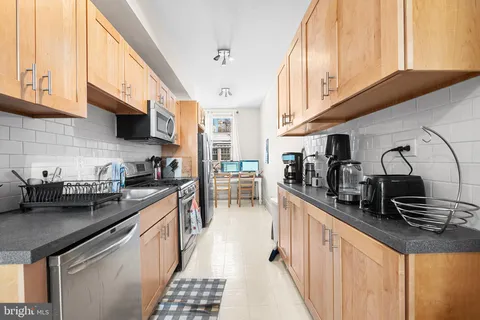 a kitchen with stainless steel appliances a sink a stove and cabinets