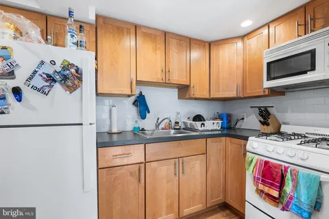 a kitchen with stainless steel appliances granite countertop a refrigerator sink stove and cabinets