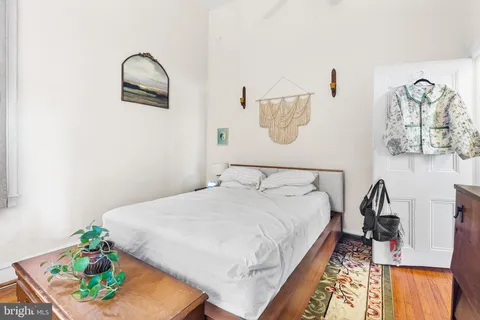 a bedroom with a bed and a painting on the wall