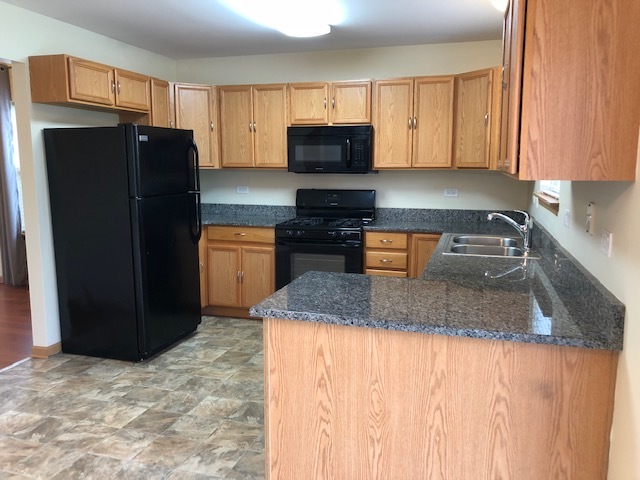 420 Kelly Court Romeoville, IL 60446 - Photo 15 of 30 a kitchen with stainless steel appliances granite countertop a refrigerator stove and microwave