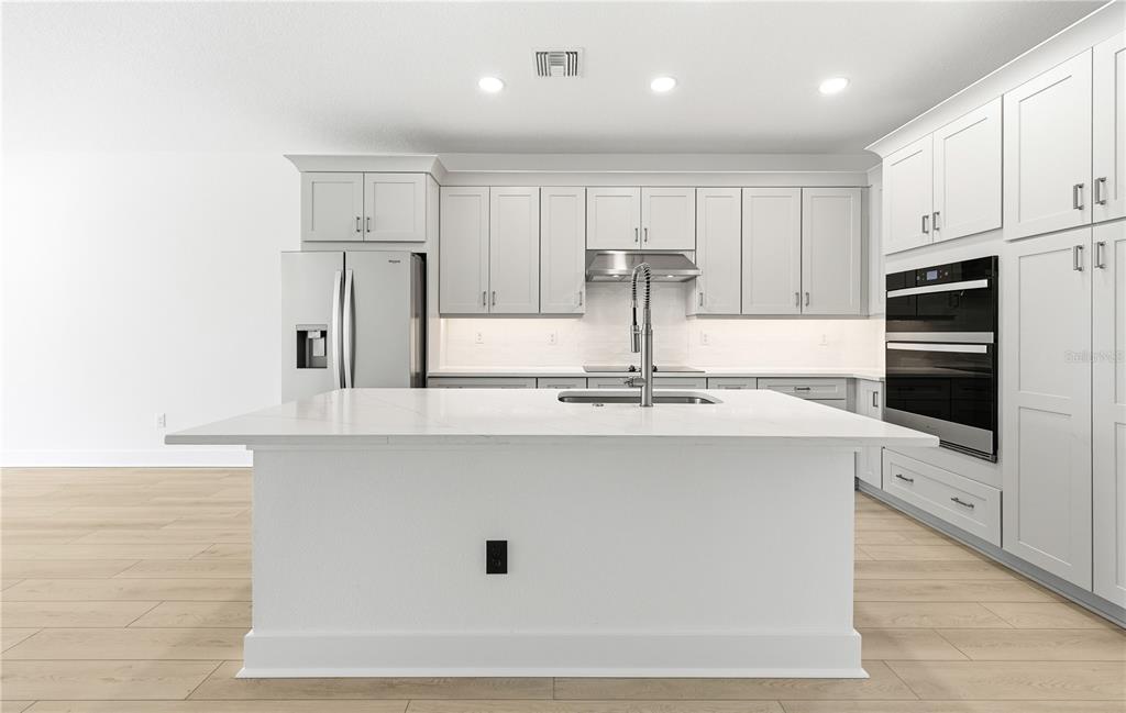 9964 Key Haven Road Seminole, FL 33777 - Photo 11 of 53 a kitchen with kitchen island sink stove and refrigerator