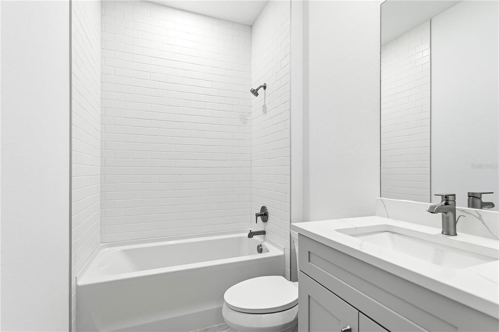 9964 Key Haven Road Seminole, FL 33777 - Photo 19 of 53 a bathroom with a granite countertop bathtub shower sink vanity mirror and toilet