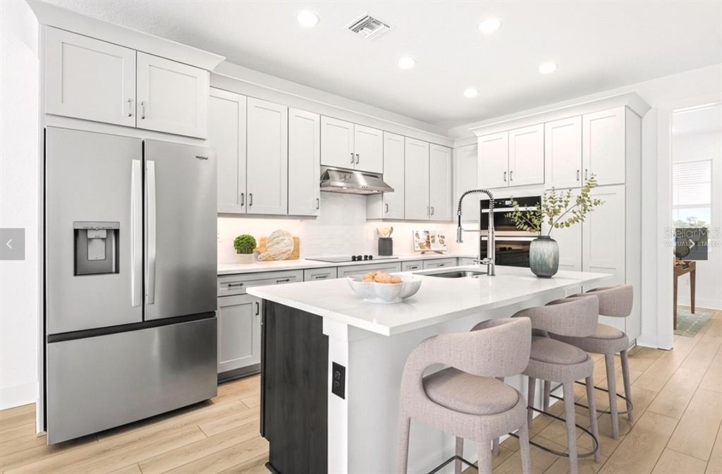 9964 Key Haven Road Seminole, FL 33777 - Photo 8 of 53 a kitchen with stainless steel appliances granite countertop a refrigerator a sink a stove a dining table and chairs