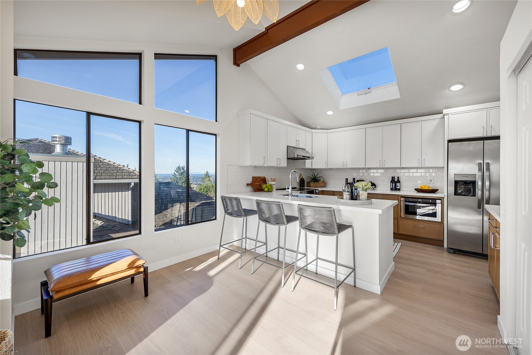4727 155th Place Southeast Bellevue, WA 98006 - Photo 16 of 38 a kitchen with stainless steel appliances kitchen island granite countertop a refrigerator a stove a sink a dining table and chairs with a large window