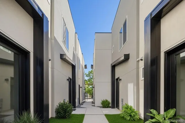 a view of a house with a potted plant and floor to ceiling window and potted plants