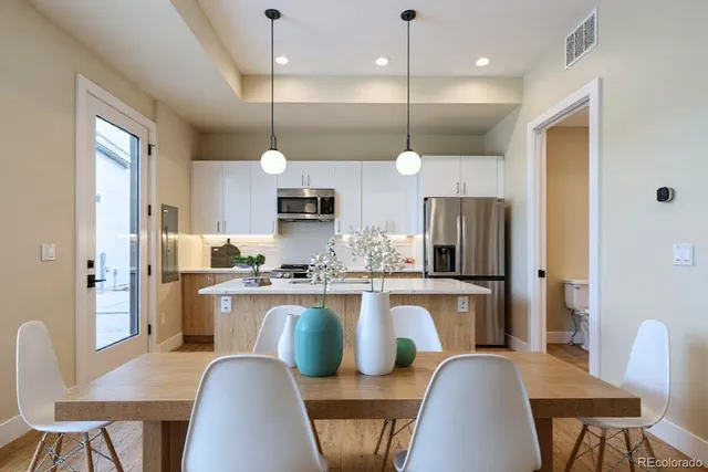 a kitchen with kitchen island a refrigerator a stove a kitchen island with chairs and wooden floor