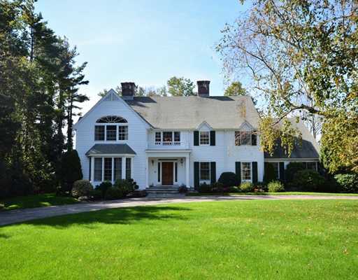 a front view of a house with a yard and trees