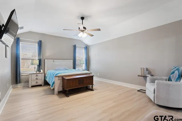 a spacious bedroom with a bed and a chandelier