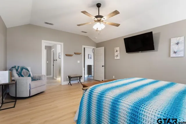 a bedroom with a large bed a flat screen tv and couches