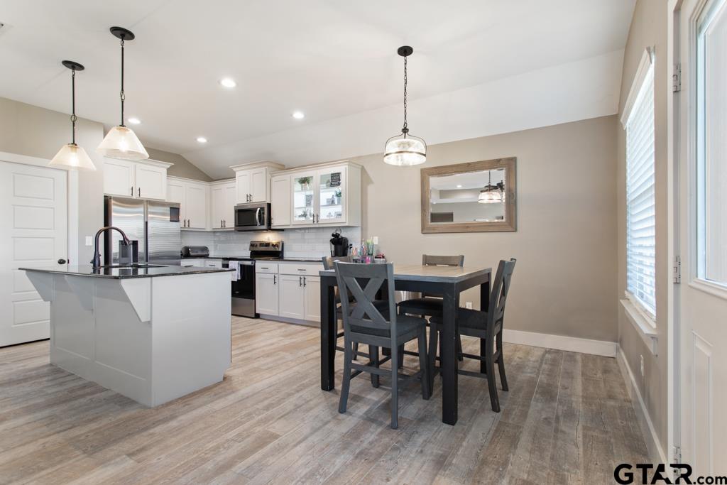 15422 Anna Lane Lindale, TX 75771 - Photo 7 of 28 a view of a dining room and livingroom with furniture wooden floor a rug a rug a fireplace and a chandelier