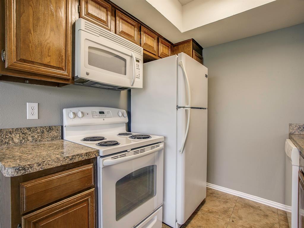 4492 Chaha Road, Unit 102 Garland, TX 75043 - Photo 11 of 40 a kitchen with stainless steel appliances granite countertop a stove microwave and refrigerator