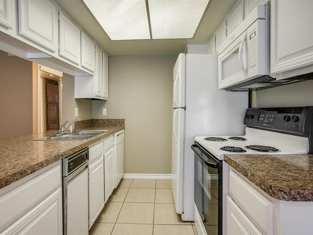 4492 Chaha Road, Unit 102 Garland, TX 75043 - Photo 29 of 40 a kitchen with stainless steel appliances granite countertop a stove a sink and a refrigerator