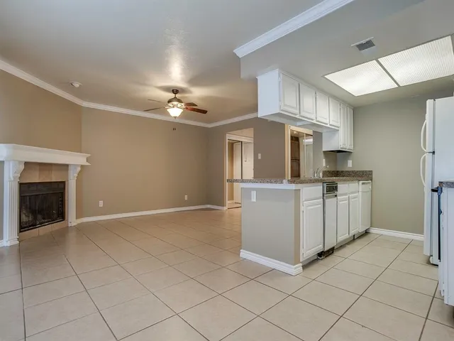 en empty room with windows and chandelier fan