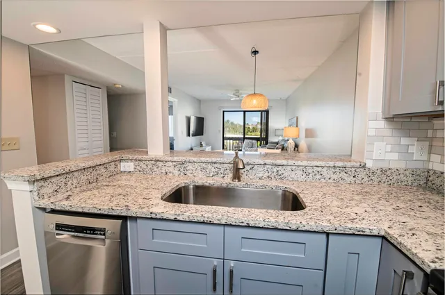 a kitchen with granite countertop a sink and a wooden cabinets