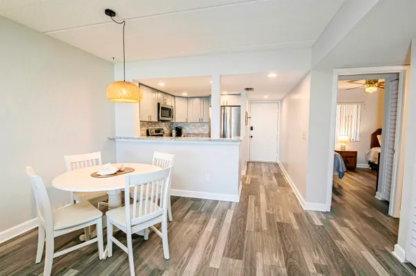 a view of a dining room and livingroom with furniture wooden floor a chandelier