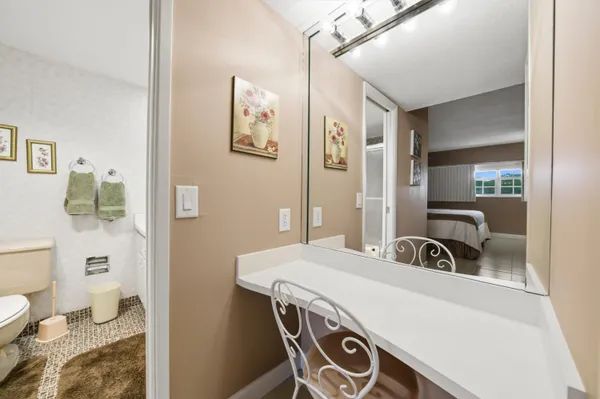 a bathroom with a granite countertop toilet sink and mirror