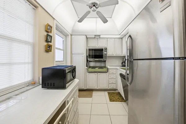 a kitchen with stainless steel appliances a refrigerator sink and microwave