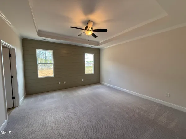an empty room with windows and ceiling fan