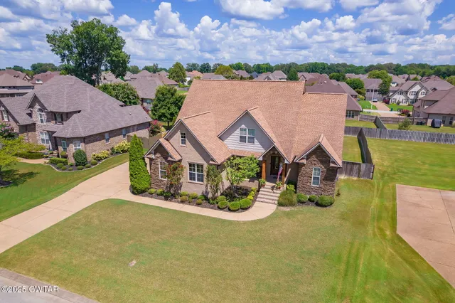 a front view of a house with a garden and yard